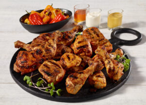 Cuisses, hauts de cuisse et pilon de poulet Ferme des Voltigeurs dans assiette noir.
