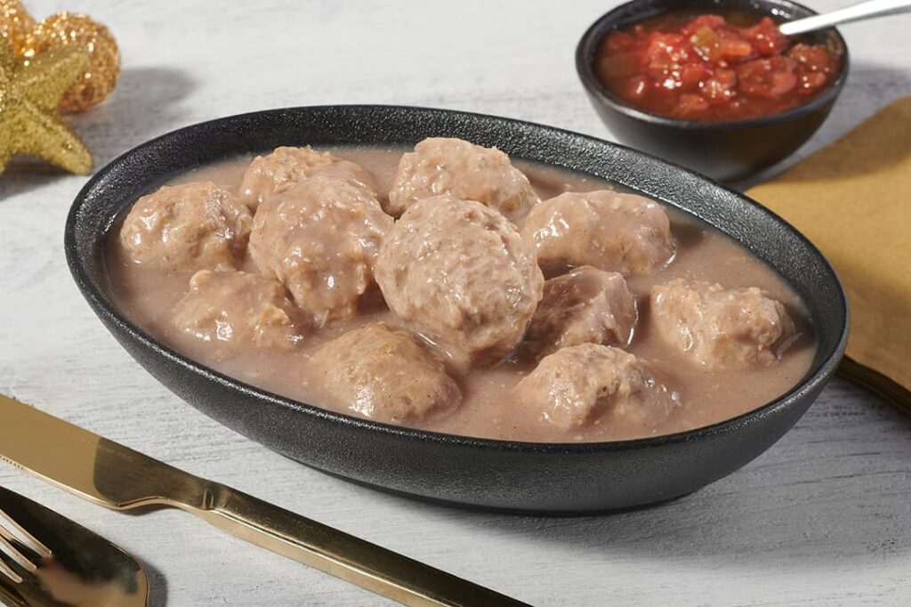 Assiette avec ragoût de boulettes au poulet de grain Ferme des Voltigeurs, ambiance des fêtes. / Plate with grain-fed chicken meatball stew from Ferme des Voltigeurs, holiday ambiance.