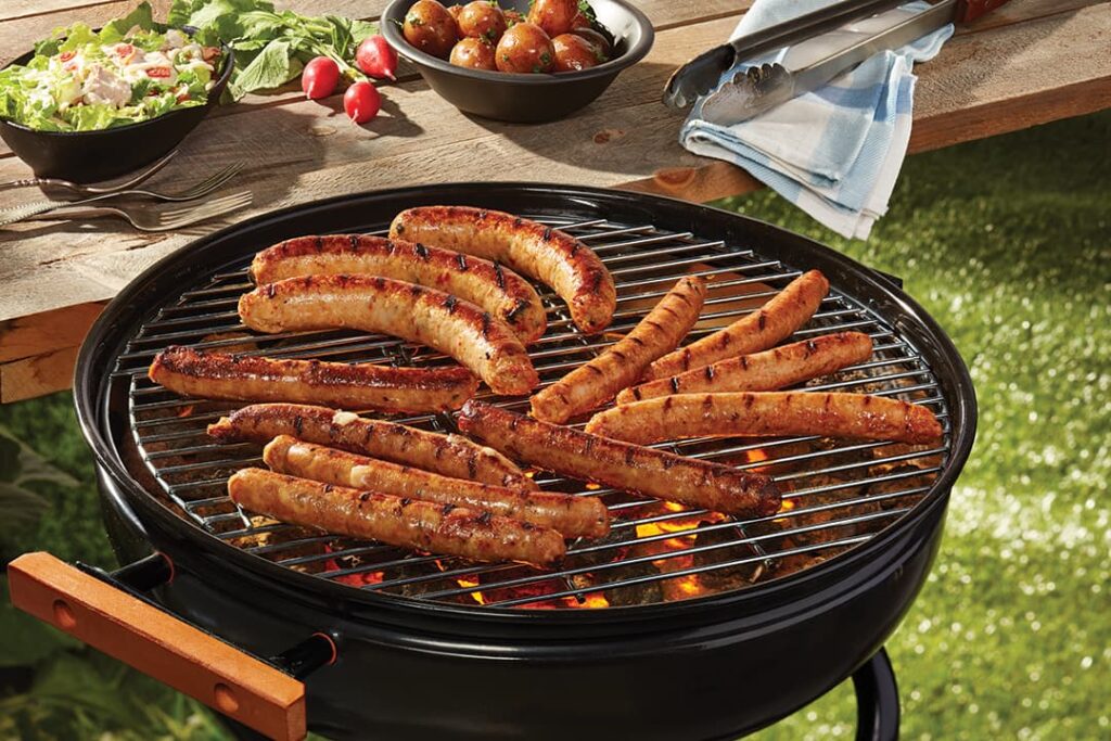 Saucisses Ferme des Voltigeurs en cuisson sur BBQ ambiance d'été
