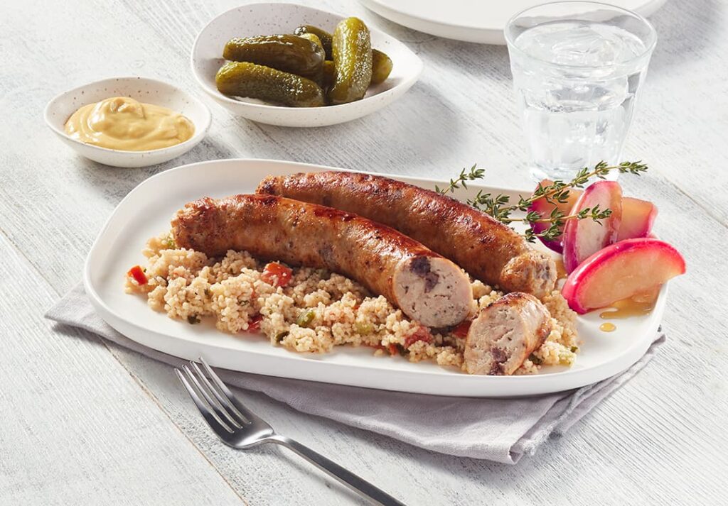 Photo ambiance de la saucisse aux pommes et canneberges de Ferme des Voltigeurs, format carrousel. / Lifestyle photo of Ferme des Voltigeurs' Apple & Cranberry Sausage, carousel format.