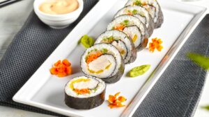 Recette de sushis au poulet servis dans une assiette blanche de Ferme des Voltigeurs. / Chicken sushi recipe served on a white Ferme des Voltigeurs plate.