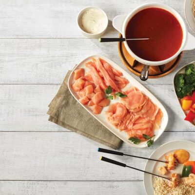 Ferme des Voltigeurs fondue chinoise au poulet de grain sur table avec bouillon, légumes et accompagnements.