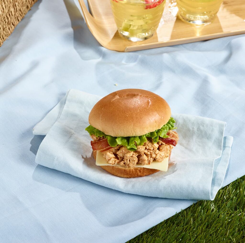 Burger Bootlager Ferme des Voltigeurs dans une ambiance pic-nic. / Ferme des Voltigeurs Bootlager Burger in a Picnic-Inspired Setting.