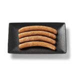 Saucisse de poulet aux fines herbes Ferme des Voltigeurs sur un plateau de présentation