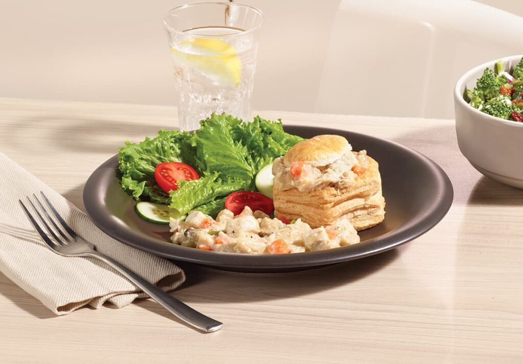 Garniture vol-au-vent au poulet de grain Ferme des Voltigeurs dans une coquille pour vol-au-vent présentée dans une assiette avec de la salade