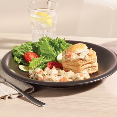 Garniture vol-au-vent au poulet de grain Ferme des Voltigeurs dans une coquille pour vol-au-vent présentée dans une assiette avec de la salade