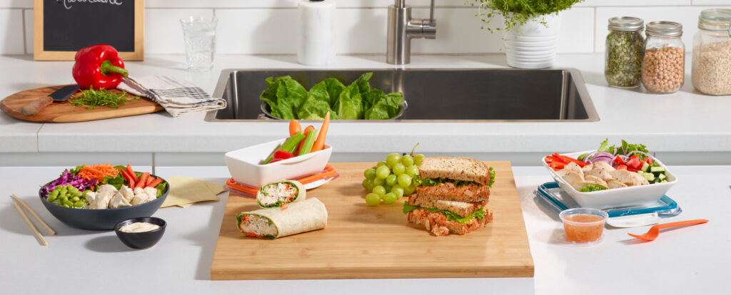 Table avec lunchs - sandwichs, salades et tartinades Ferme des Voltigeurs. / Table with lunches – sandwiches, salads and spreads from Ferme des Voltigeurs.