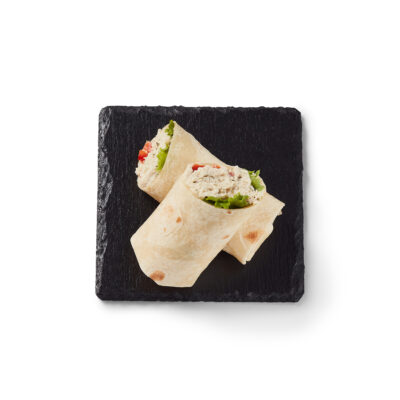 Wrap tartinade régulière Ferme des Voltigeurs dans une assiette noir sur fond blanc. / Regular Ferme des Voltigeurs Spread Wrap on a Black Plate with a White Background.