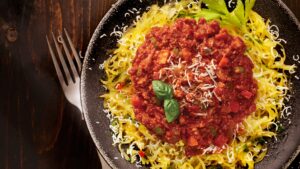 Photo bandeau site web pour recette de courge spaghetti avec la sauce au poulet de grain pour pâtes de Ferme des Voltigeurs. / Website banner image for a spaghetti squash recipe featuring Ferme des Voltigeurs' grain-fed chicken pasta sauce.